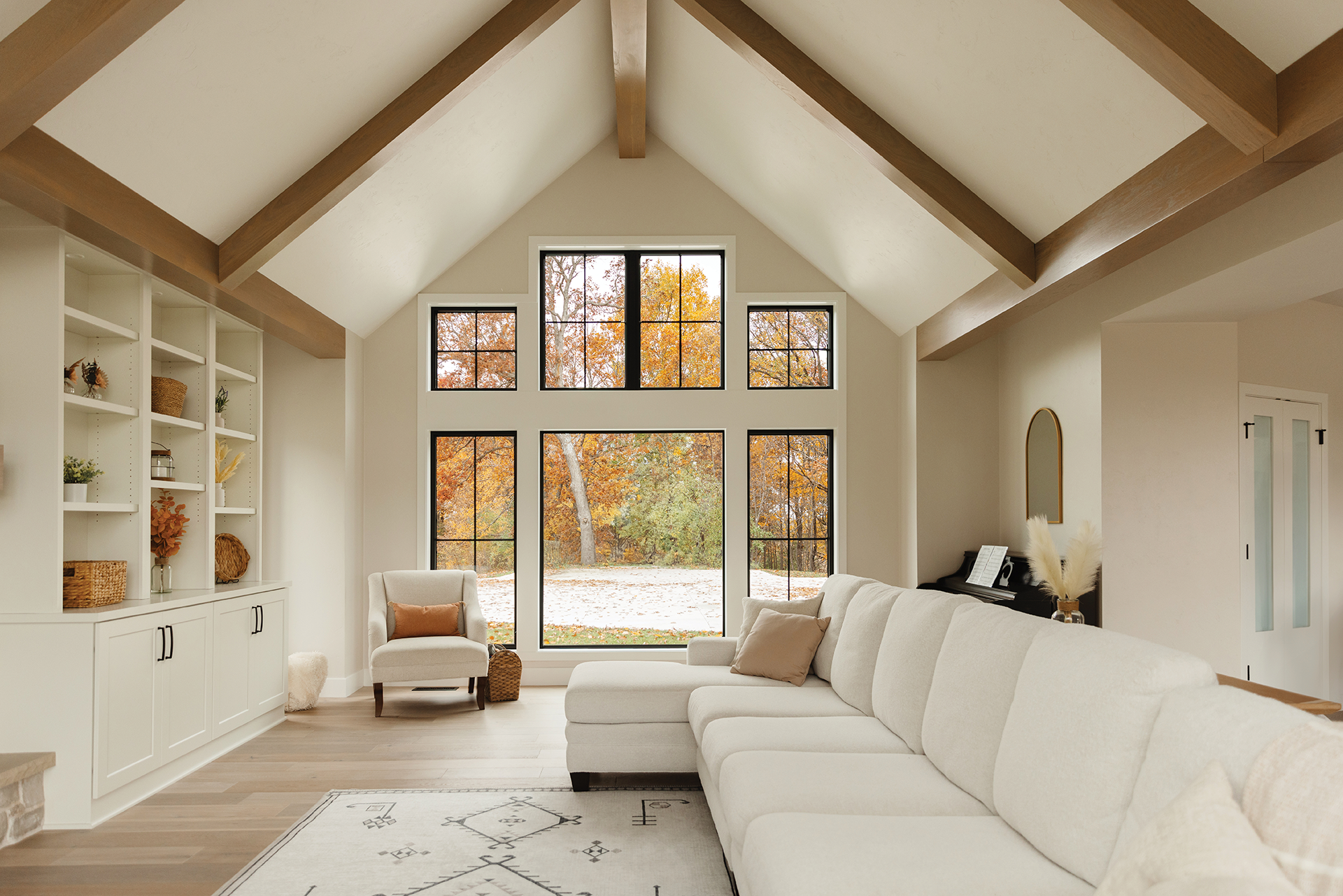 A living room with a couch , chair , and lots of windows.