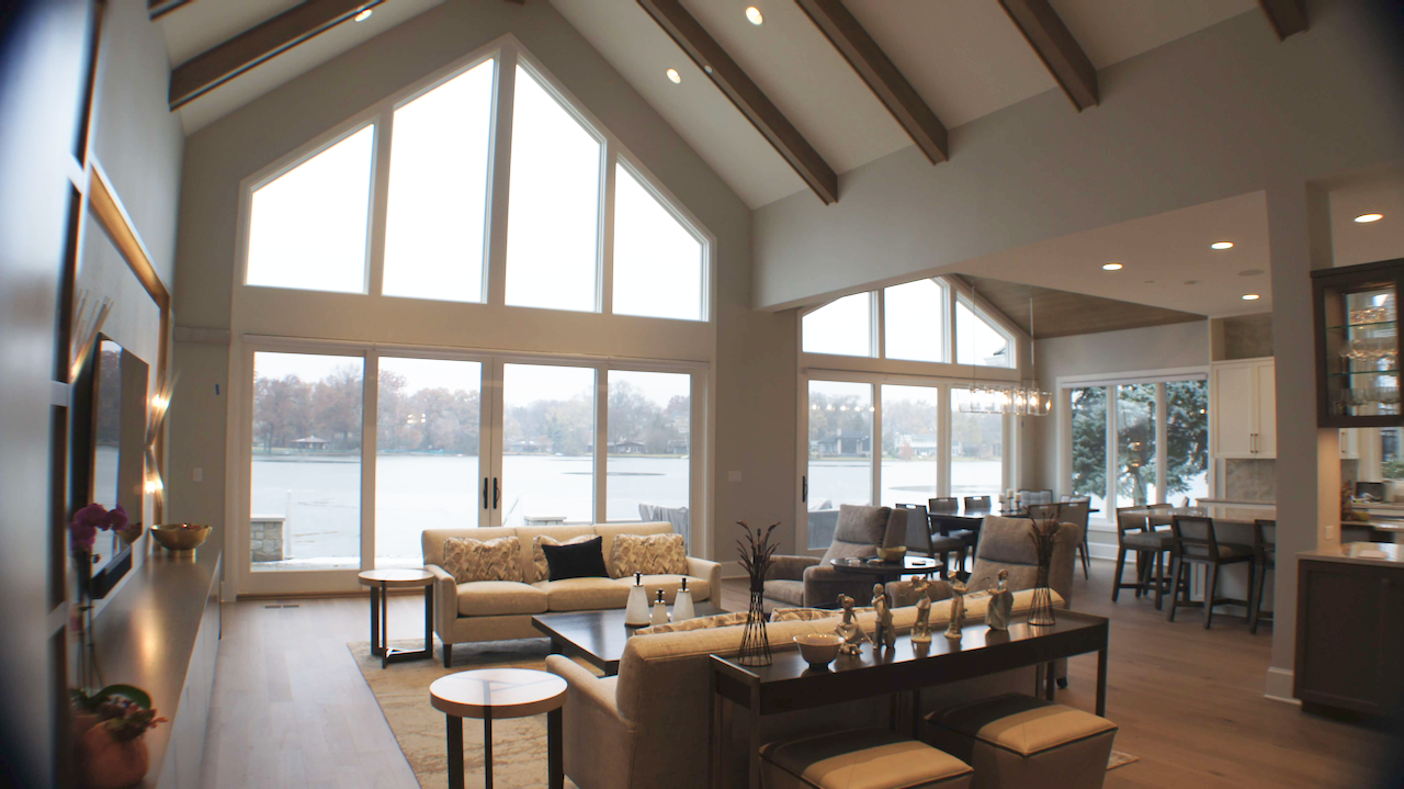 A living room with a lot of windows and a view of a lake.