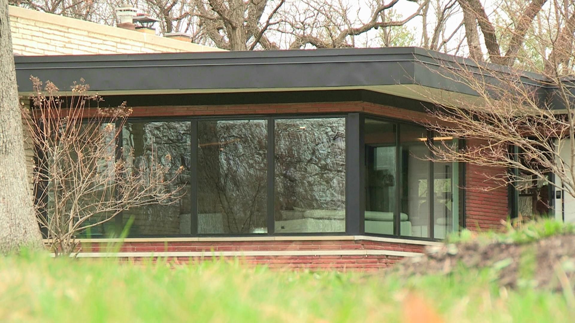 A house with a lot of windows and trees in the background.