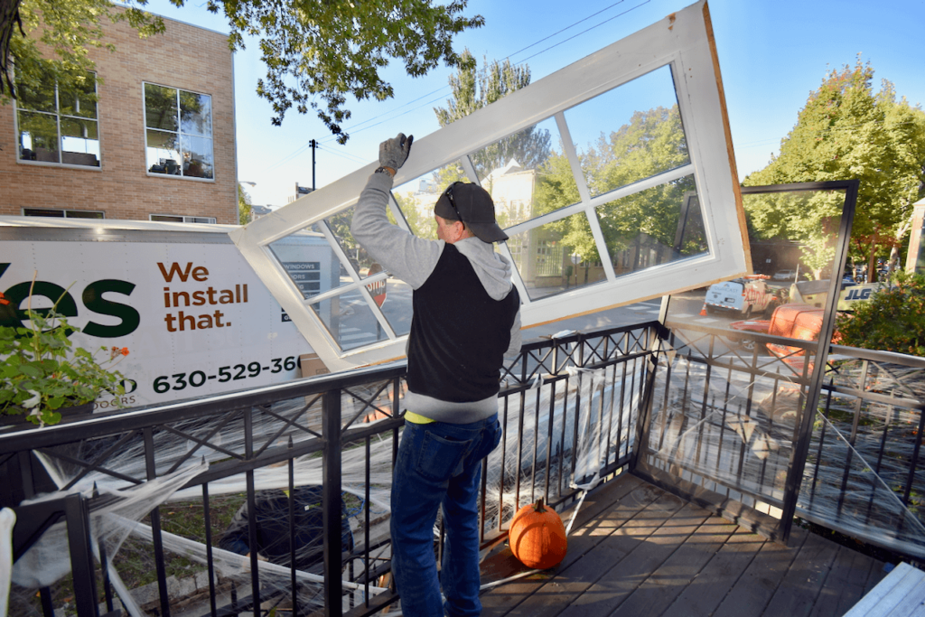 A man is installing a window on a balcony.