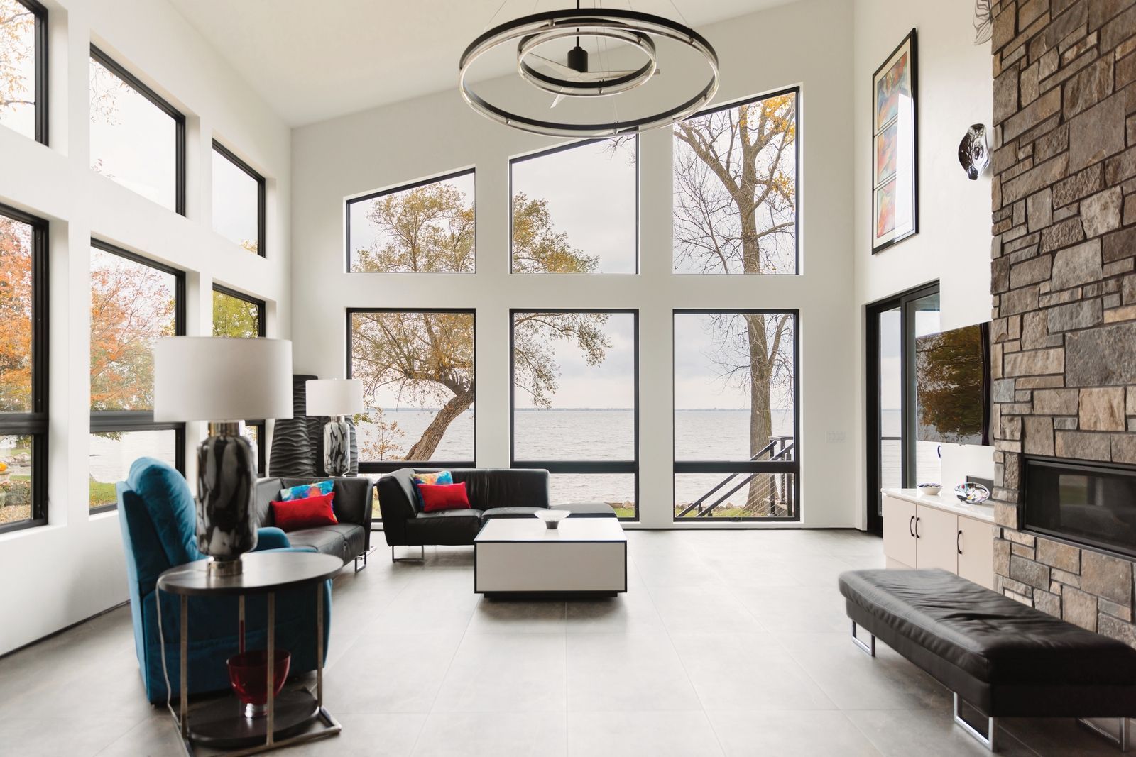A living room with a lot of windows and a fireplace.