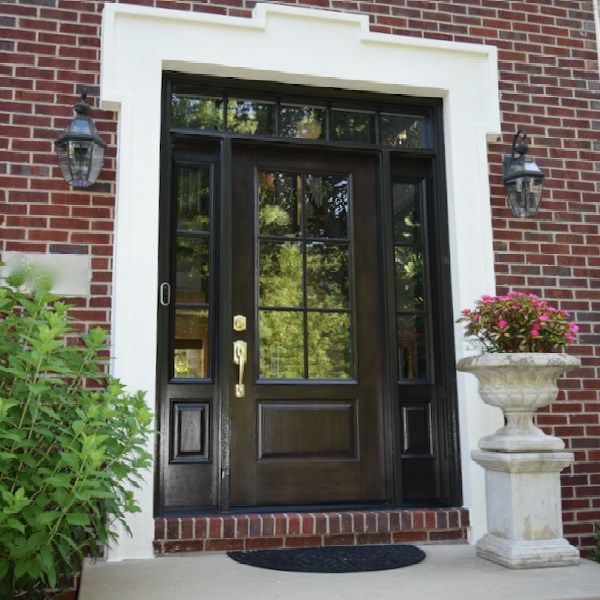 A brick house with a brown door and a white trim