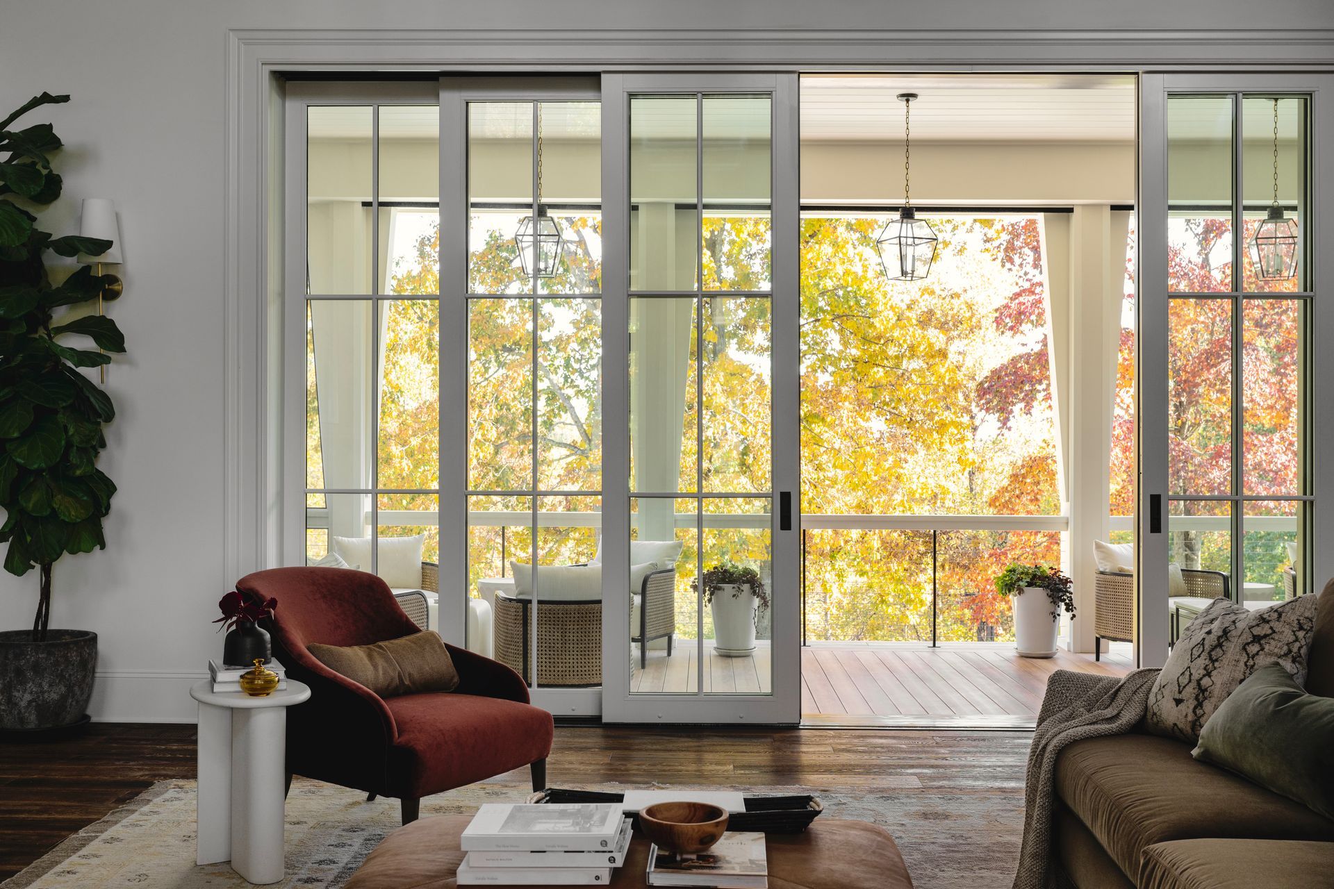 A living room with a couch , chair , table and sliding glass doors leading to a porch.