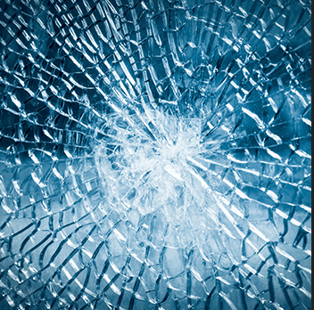 A close up of a broken glass window with a hole in it.