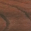 A close up of a wooden surface with a brick wall in the background.