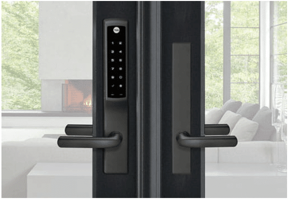 A door with a digital lock on it is open to a living room.