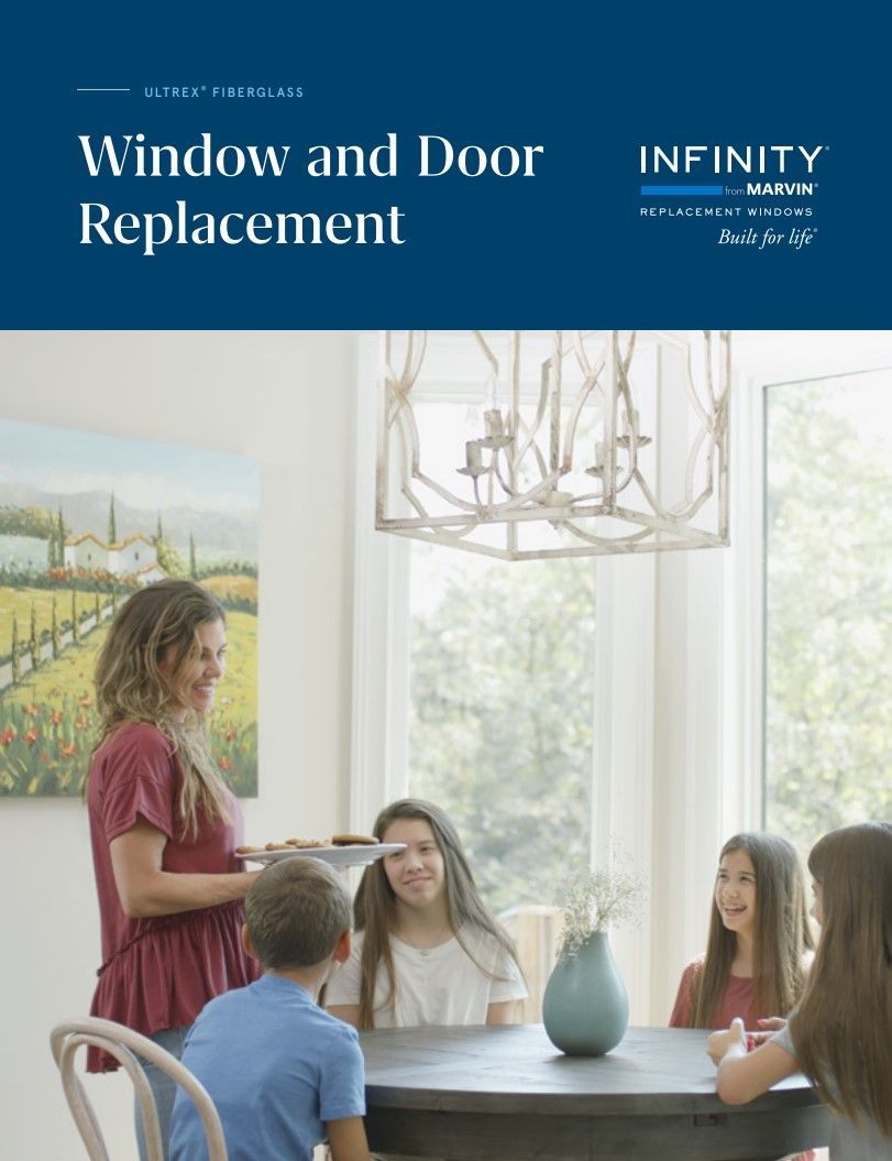 A woman and a child are sitting at a table in front of a window and door replacement brochure.