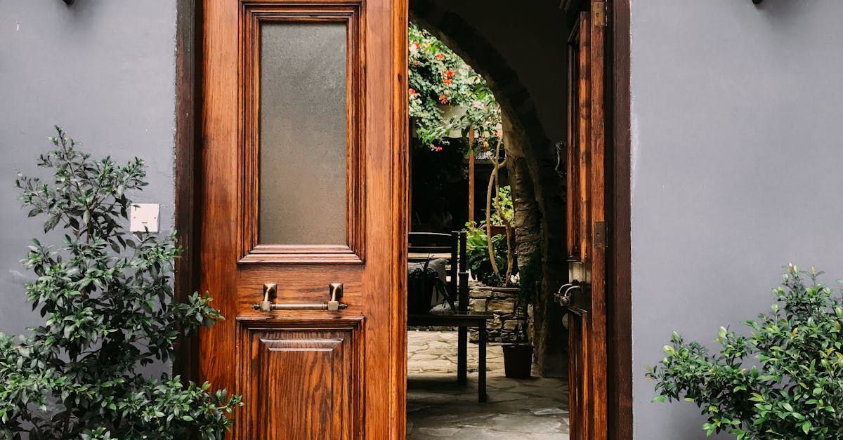 A wooden door with a glass window is open to a room.