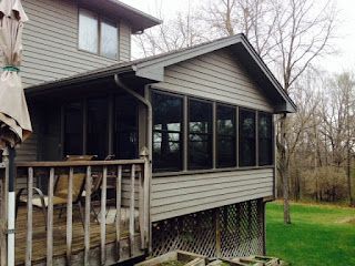 A house with a screened in porch and a deck.