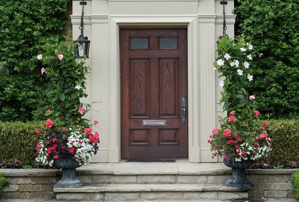 A front door of a house with flowers in front of it.