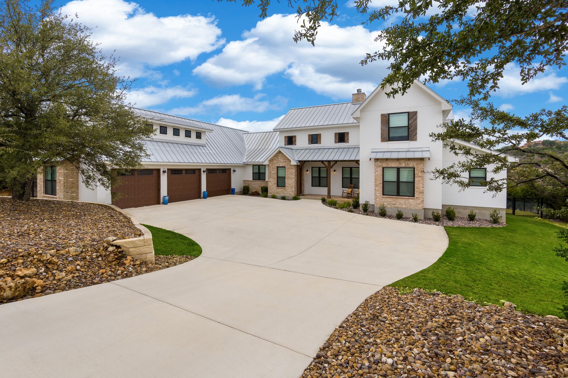 A large white house with a driveway leading to it - designed by an architect 