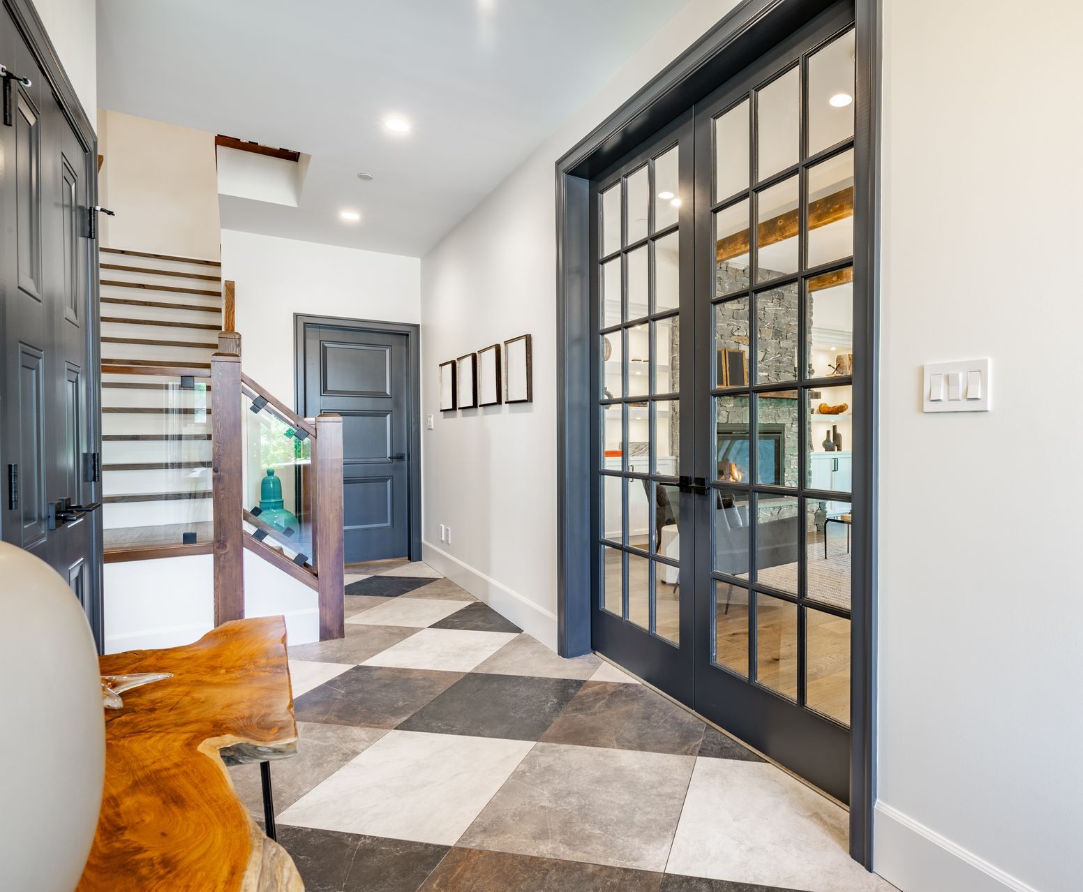 A hallway in a house with wooden floors and white walls.