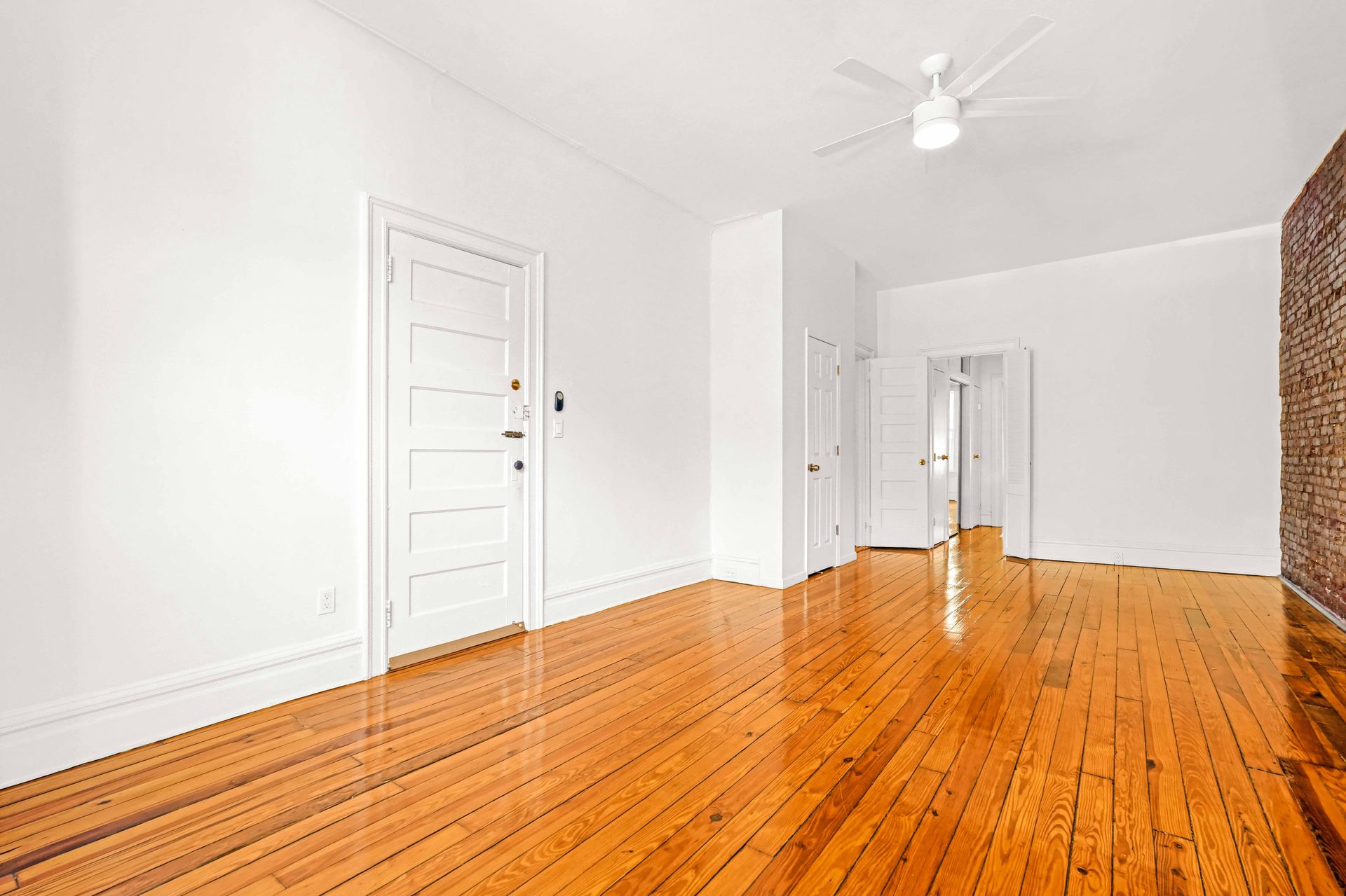 An empty room with wooden floors and white walls