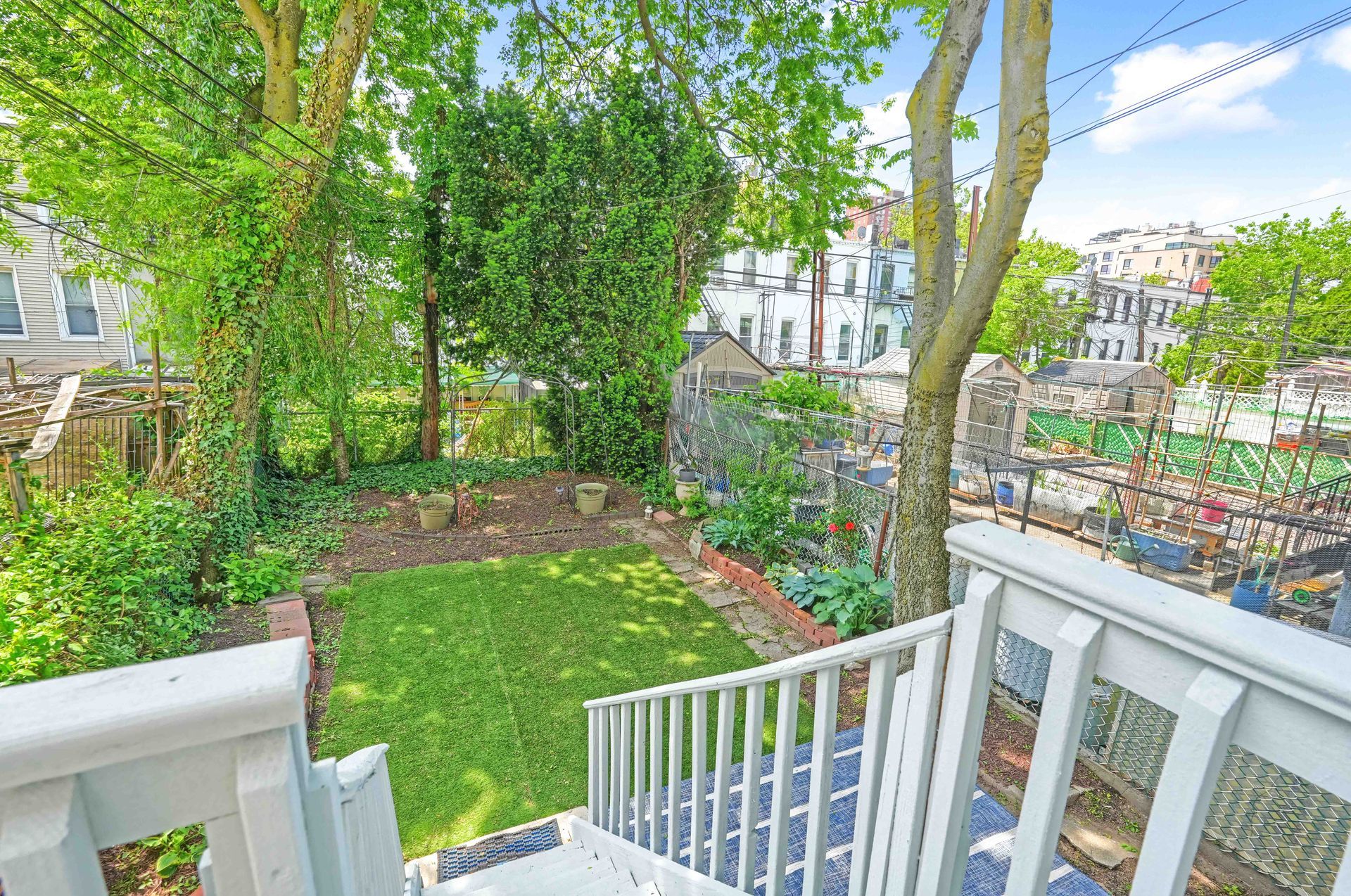 A view of a garden from a balcony with stairs leading up to it.