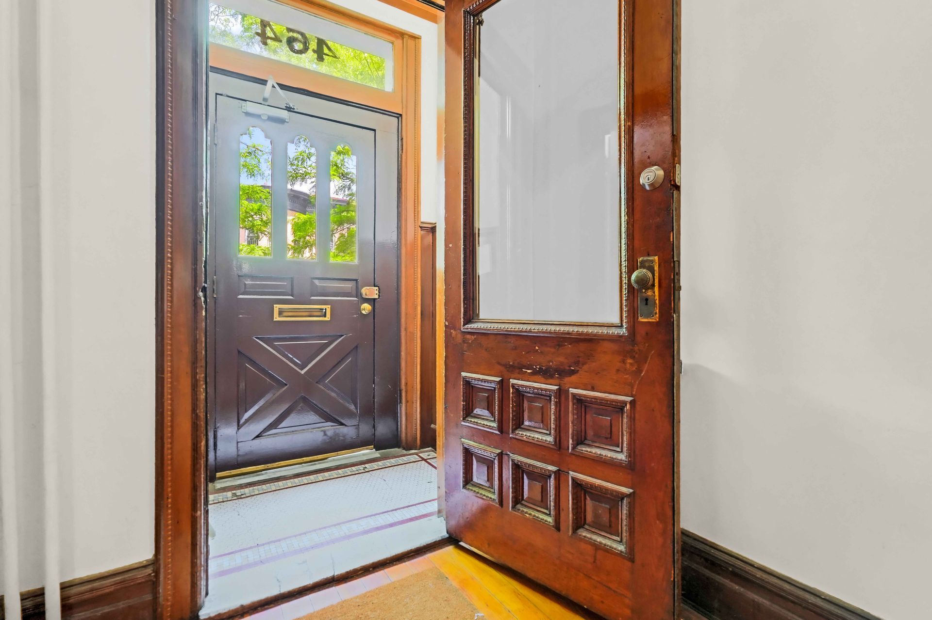 A wooden door is open to a hallway in a house.