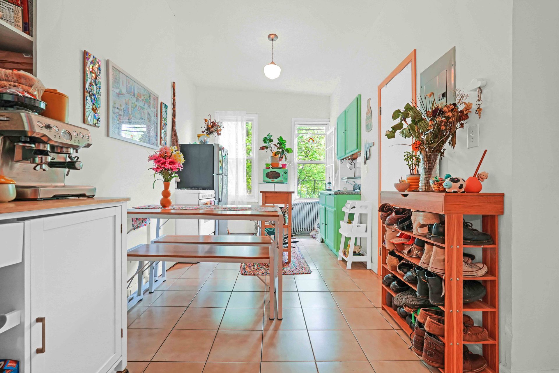A kitchen with a table and benches and a shoe rack