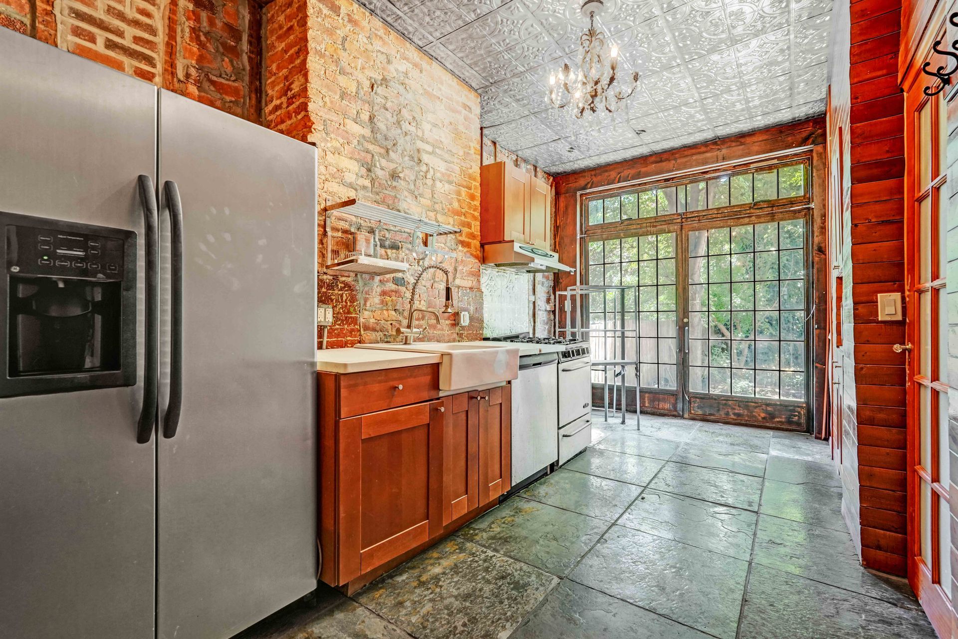 A kitchen with stainless steel appliances and wooden cabinets.
