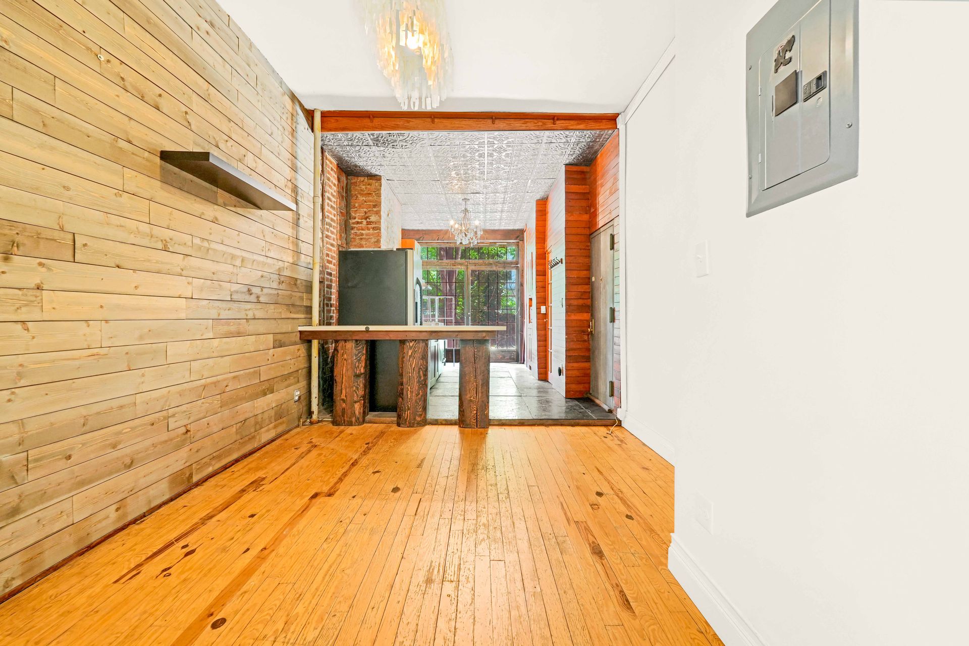 An empty room with wooden floors and a wooden wall.