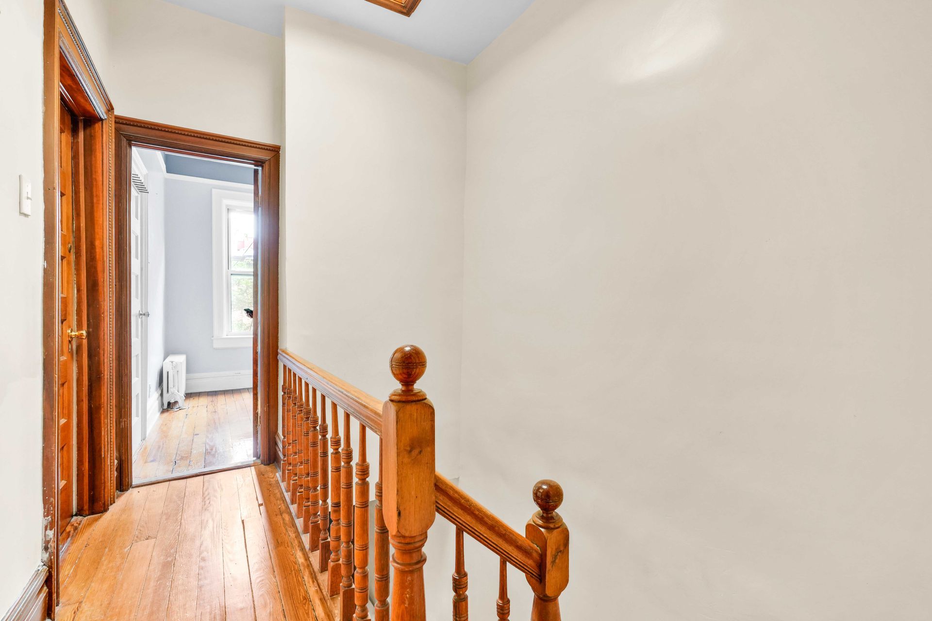 A hallway with a wooden staircase leading up to the second floor of a house.