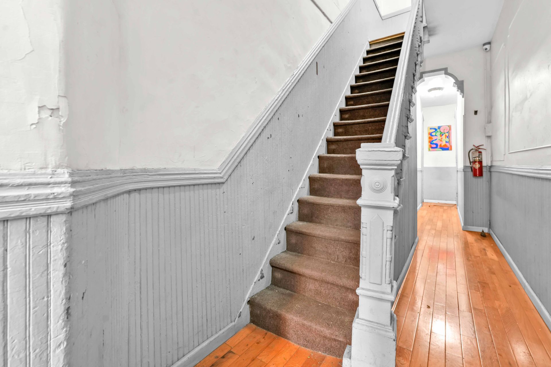 A hallway with stairs leading up to the second floor of a house.