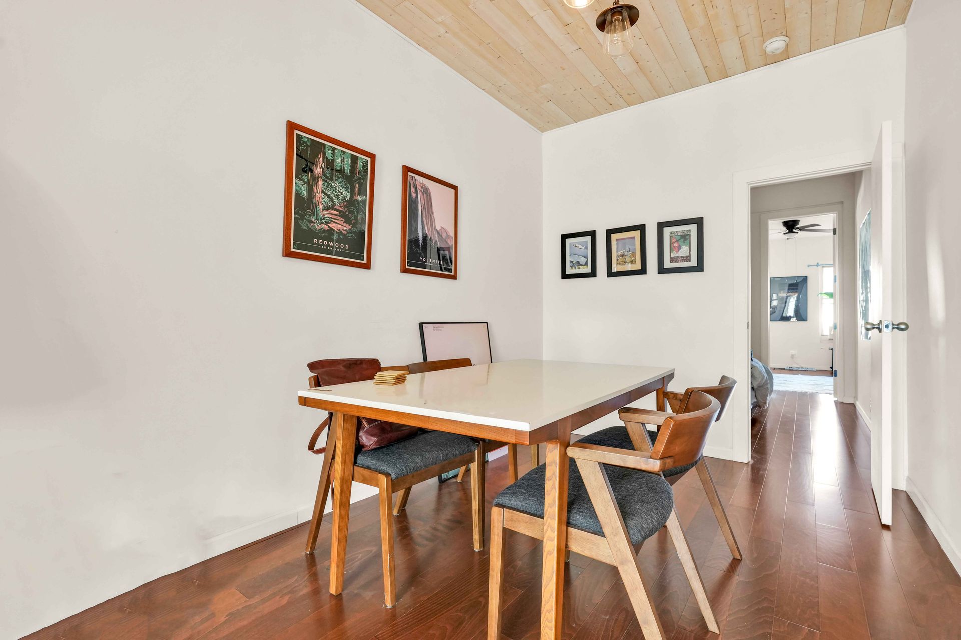 A dining room with a table and chairs and a wooden floor.
