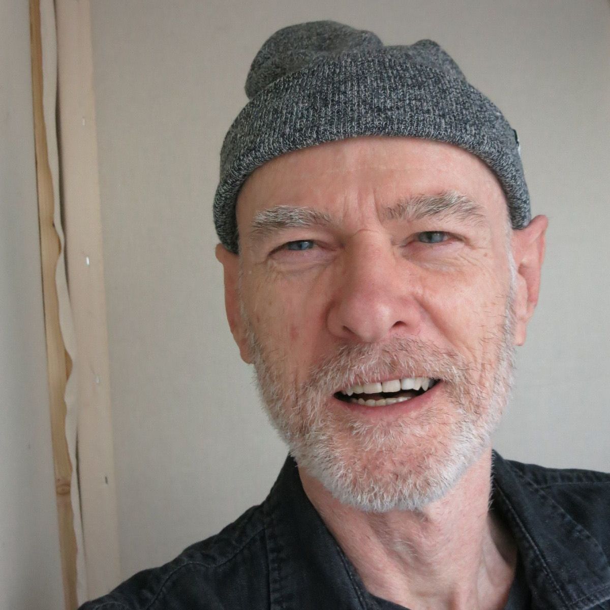 A man with a beard wearing a gray hat