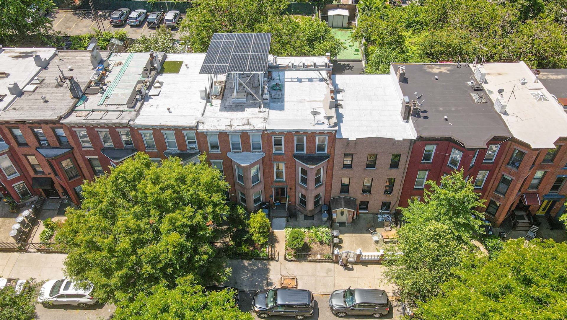 An aerial view of a row of buildings with cars parked in front of them.