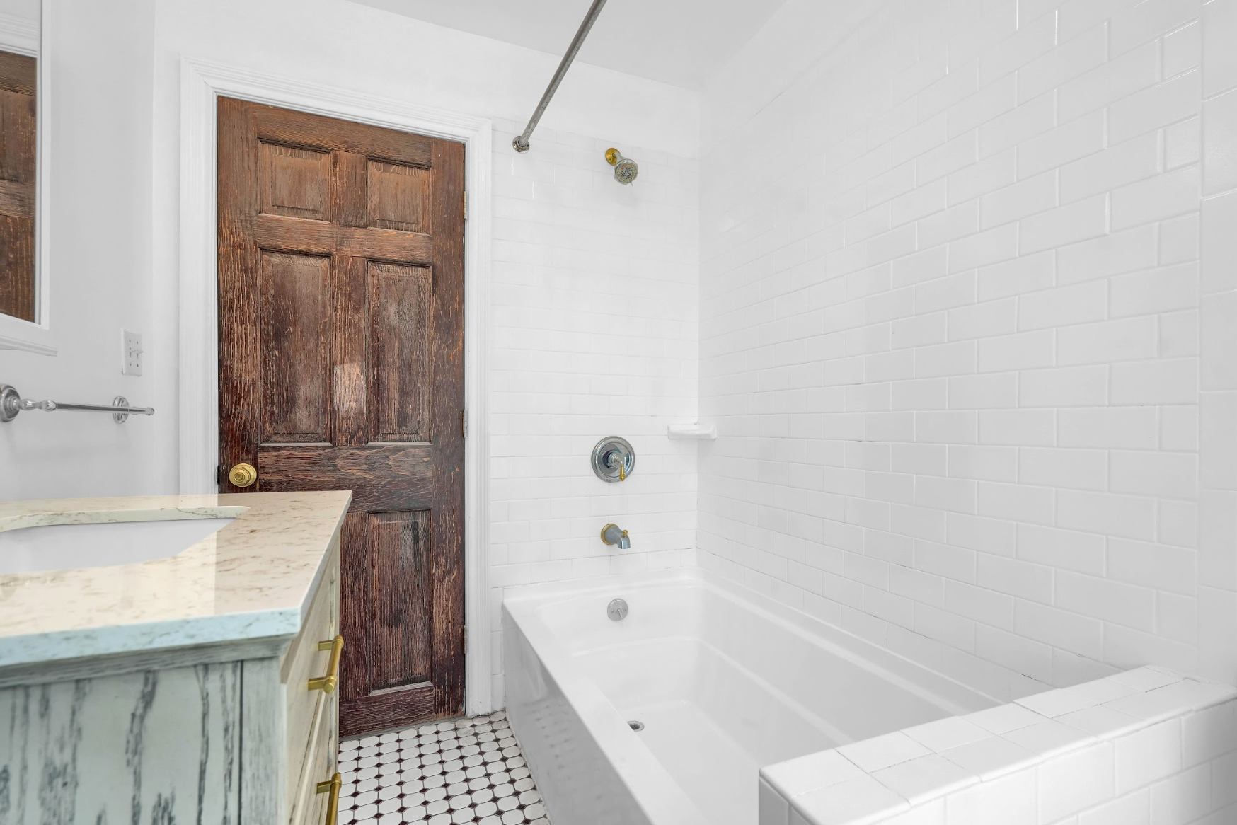 A bathroom with a sink , tub and shower.