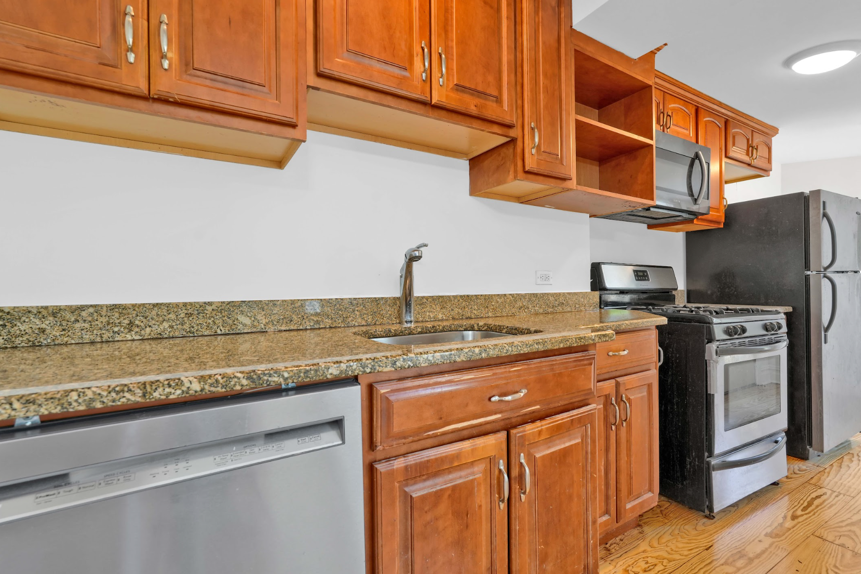 A kitchen with wooden cabinets and stainless steel appliances.