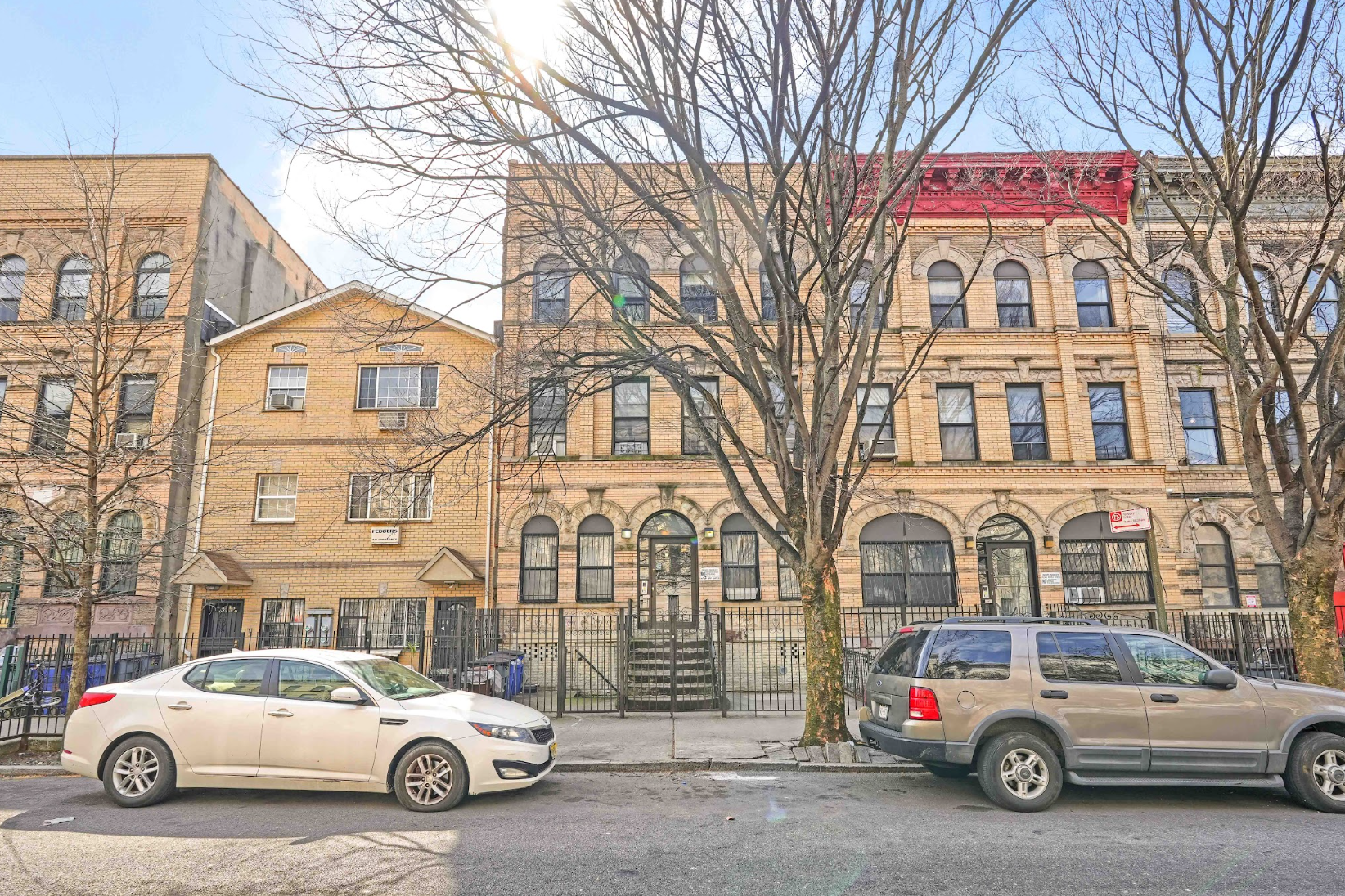 A white car is parked in front of a building