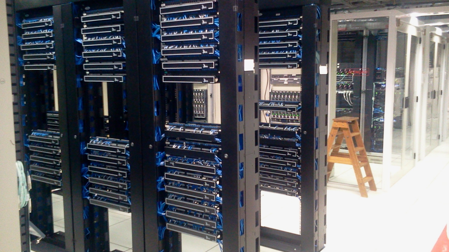 Server racks filled with network equipment in a data center corridor