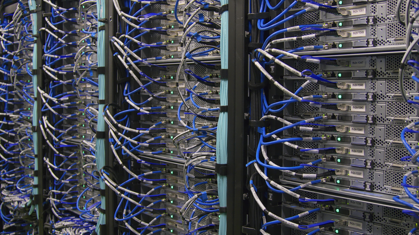 Rows of server racks with blue network cables in a data center