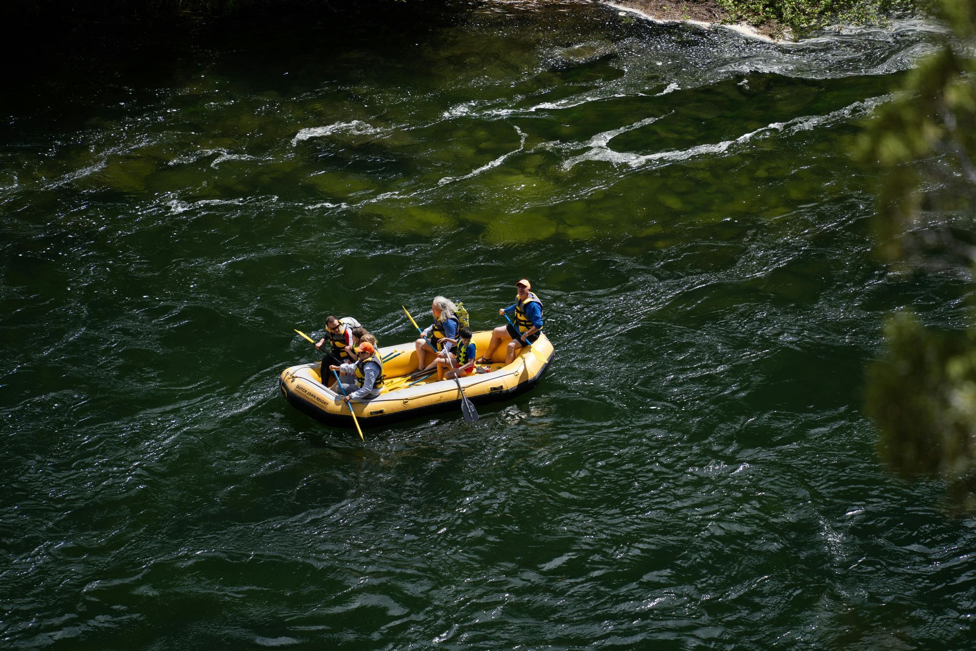 A group of people are rafting down a river in a raft.