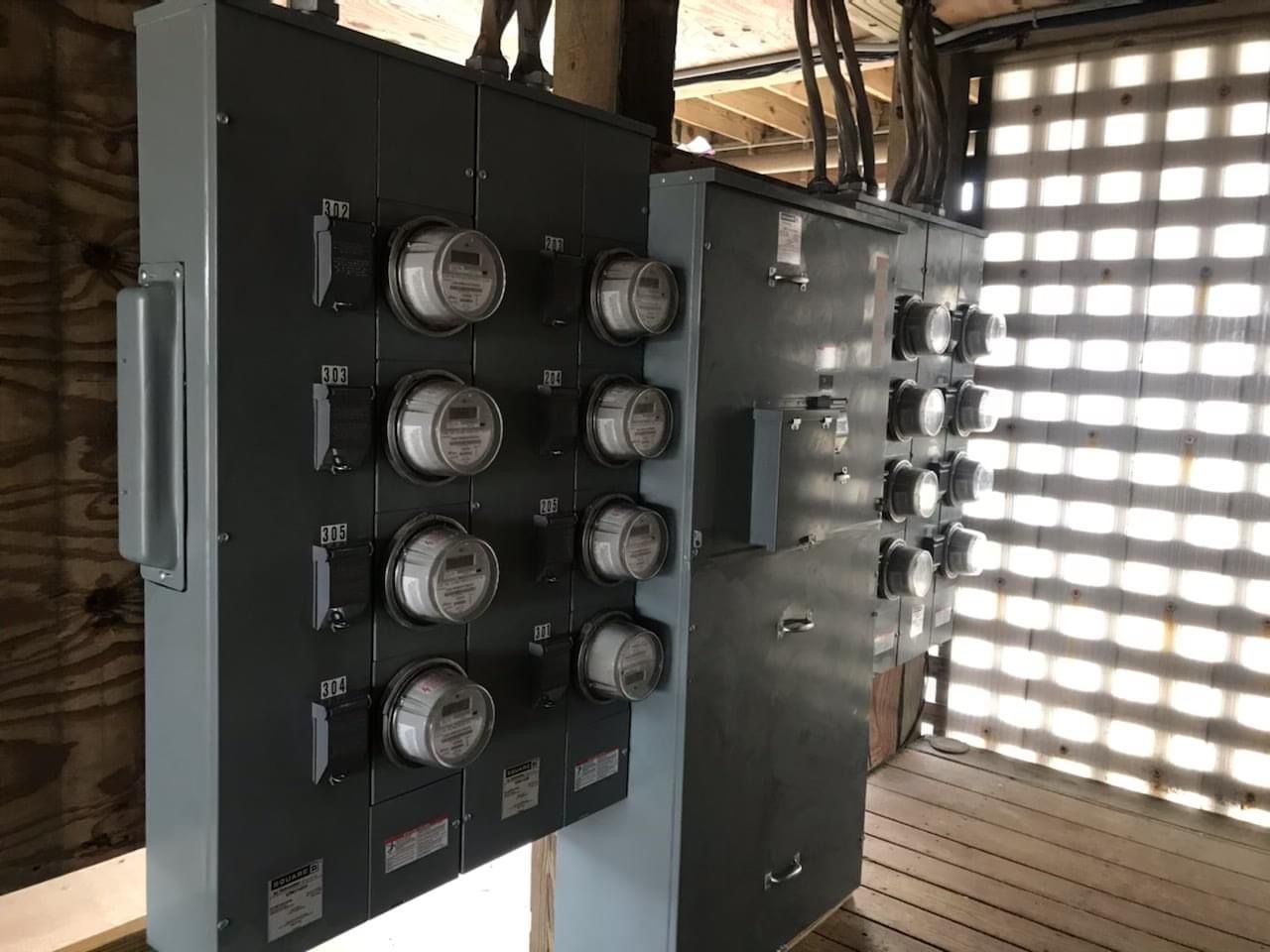 A bunch of electrical boxes with meters on them in a room.