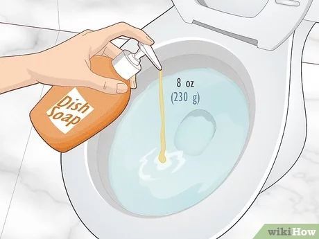 Person pouring dish soap into a toilet bowl filled with water.