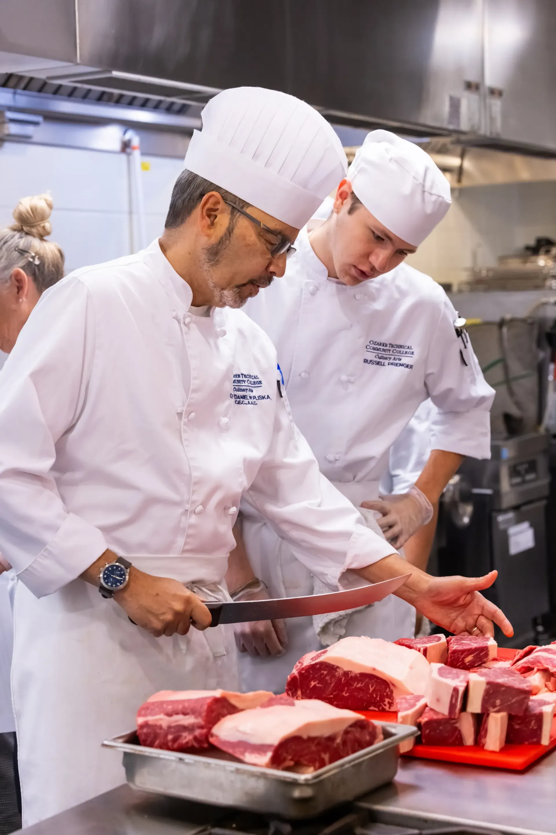teaching a student how to cut meat