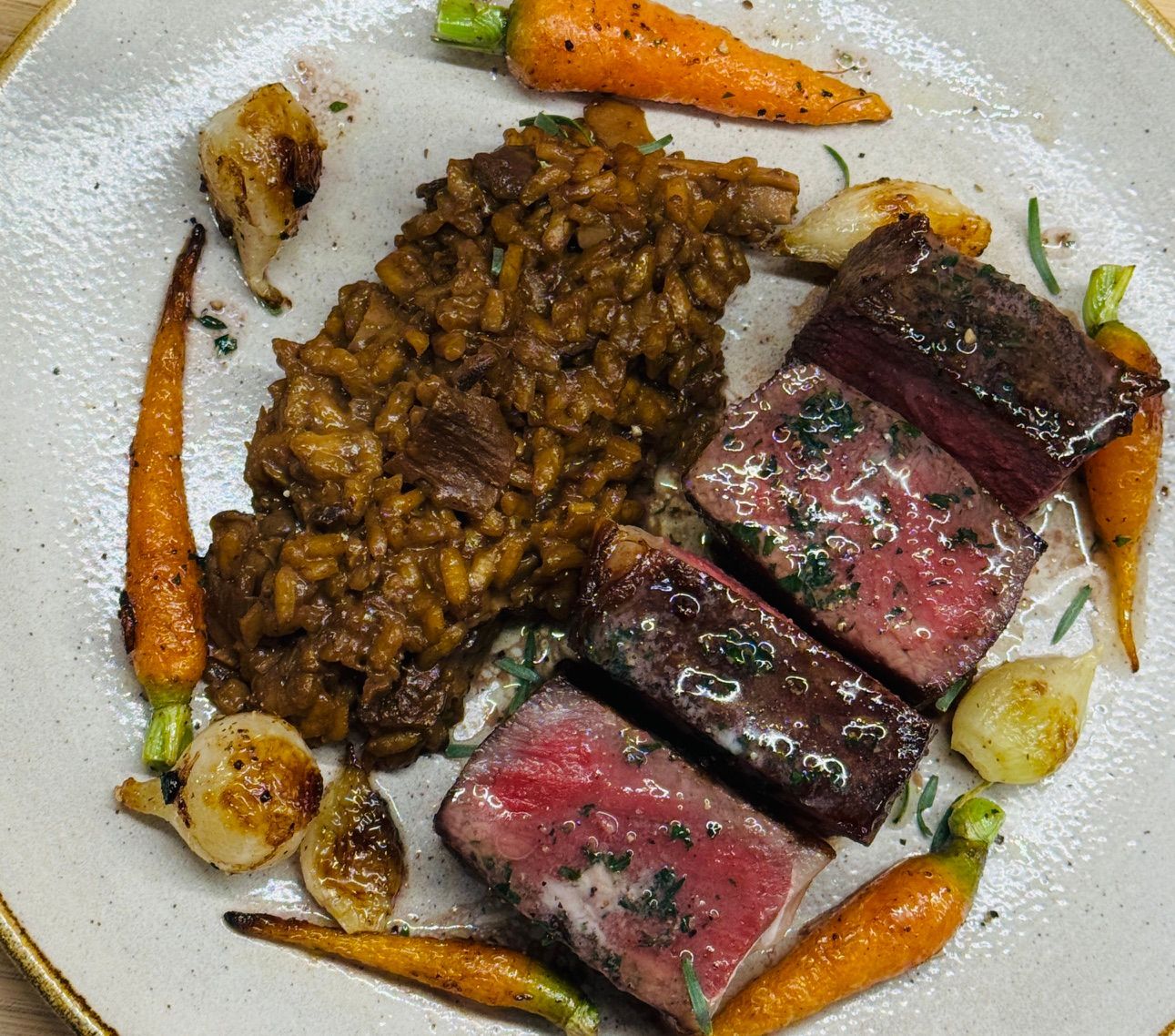 Cast Iron seared strip steak with red wine butter and wild mushroom risotto.