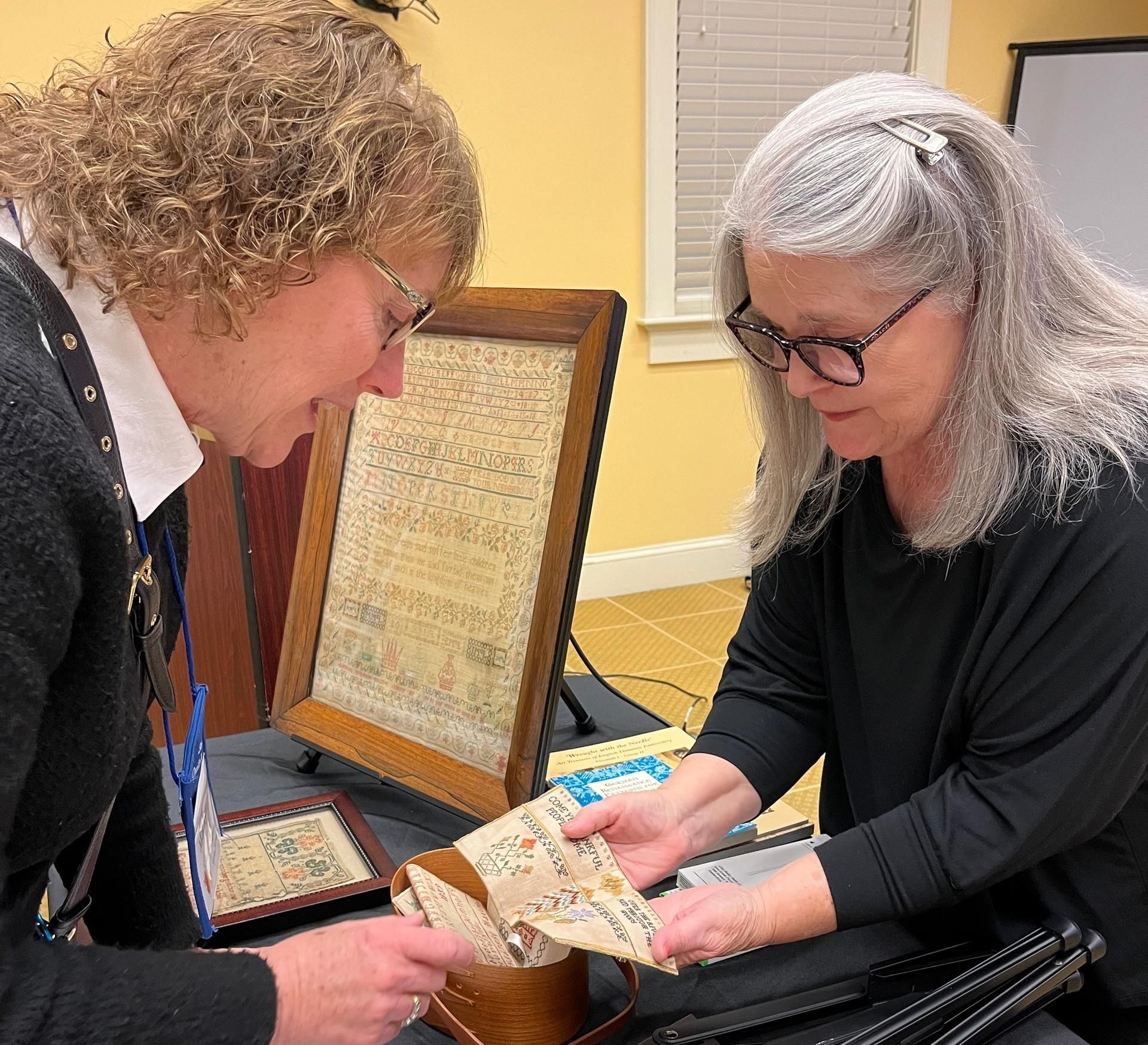 Two people examining a decorative sewing project