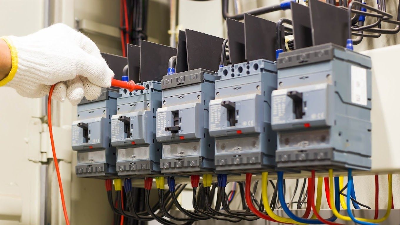 A person is using a voltmeter to test an electrical box.