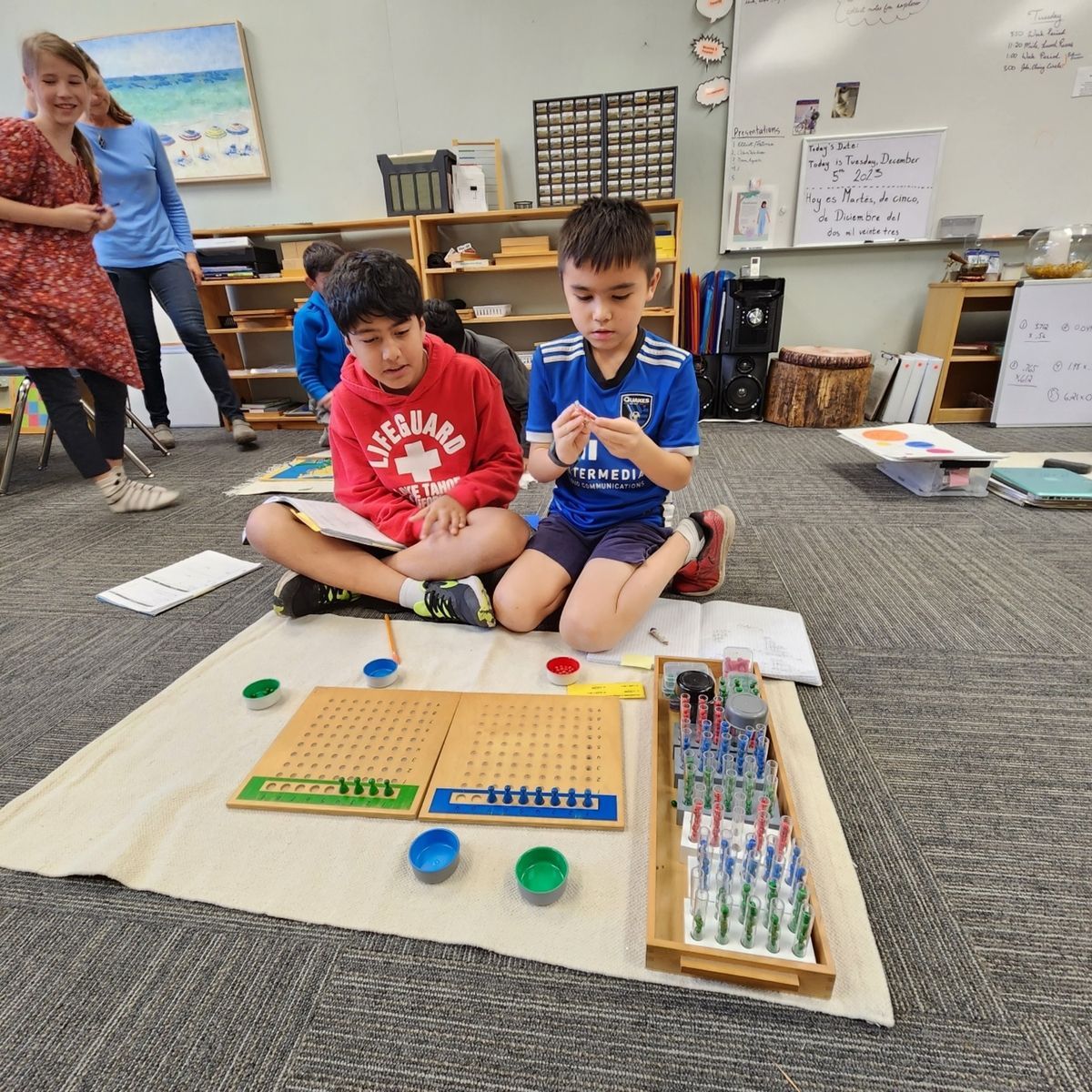 Montessori students working with montessori math peg board