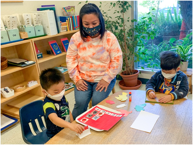 Primary teacher observing student's work