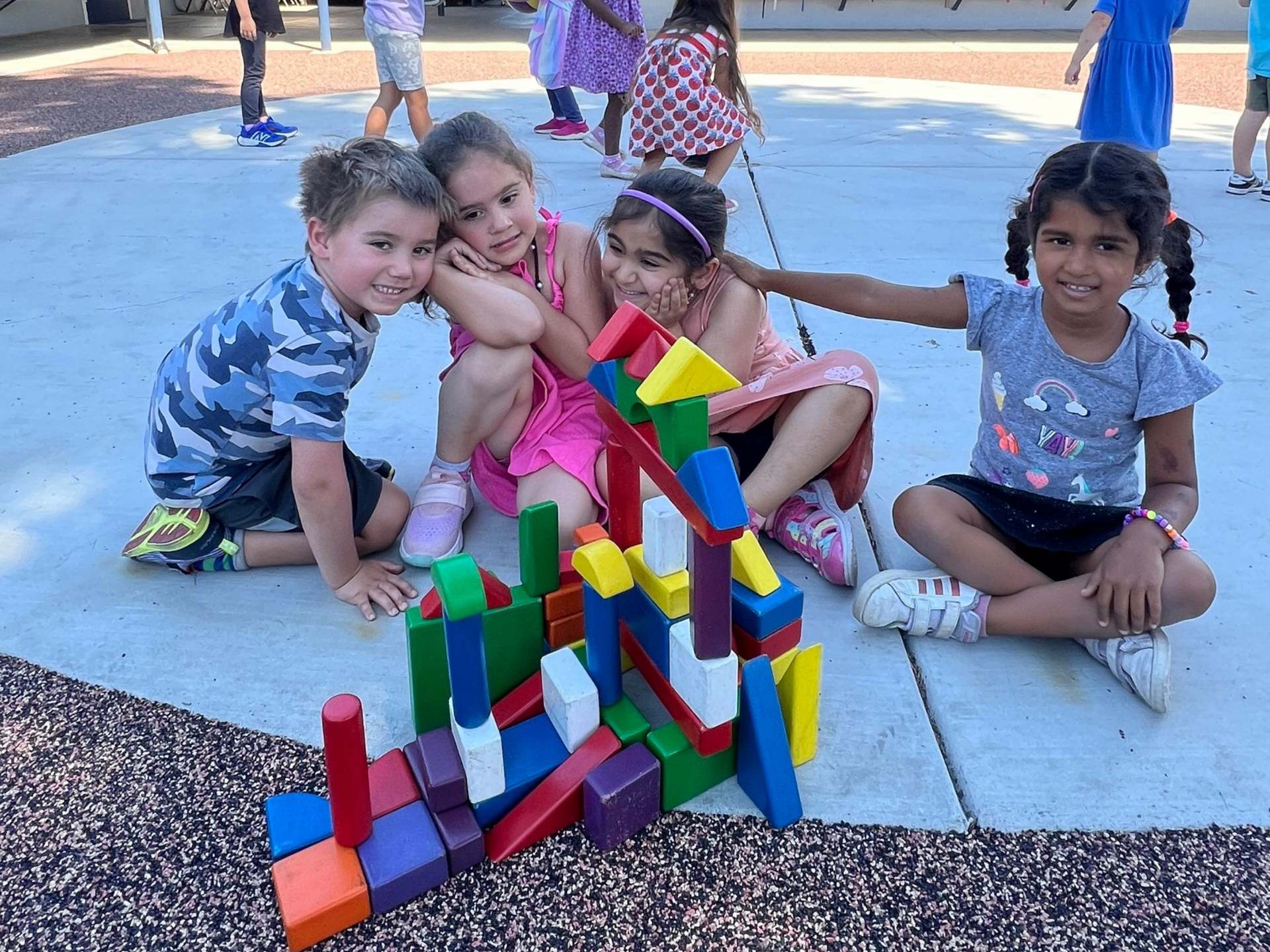 montessori children building with colorful blocks on a playground