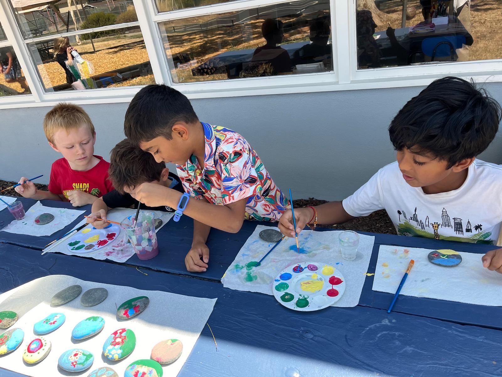 Montessori students painting outdoors