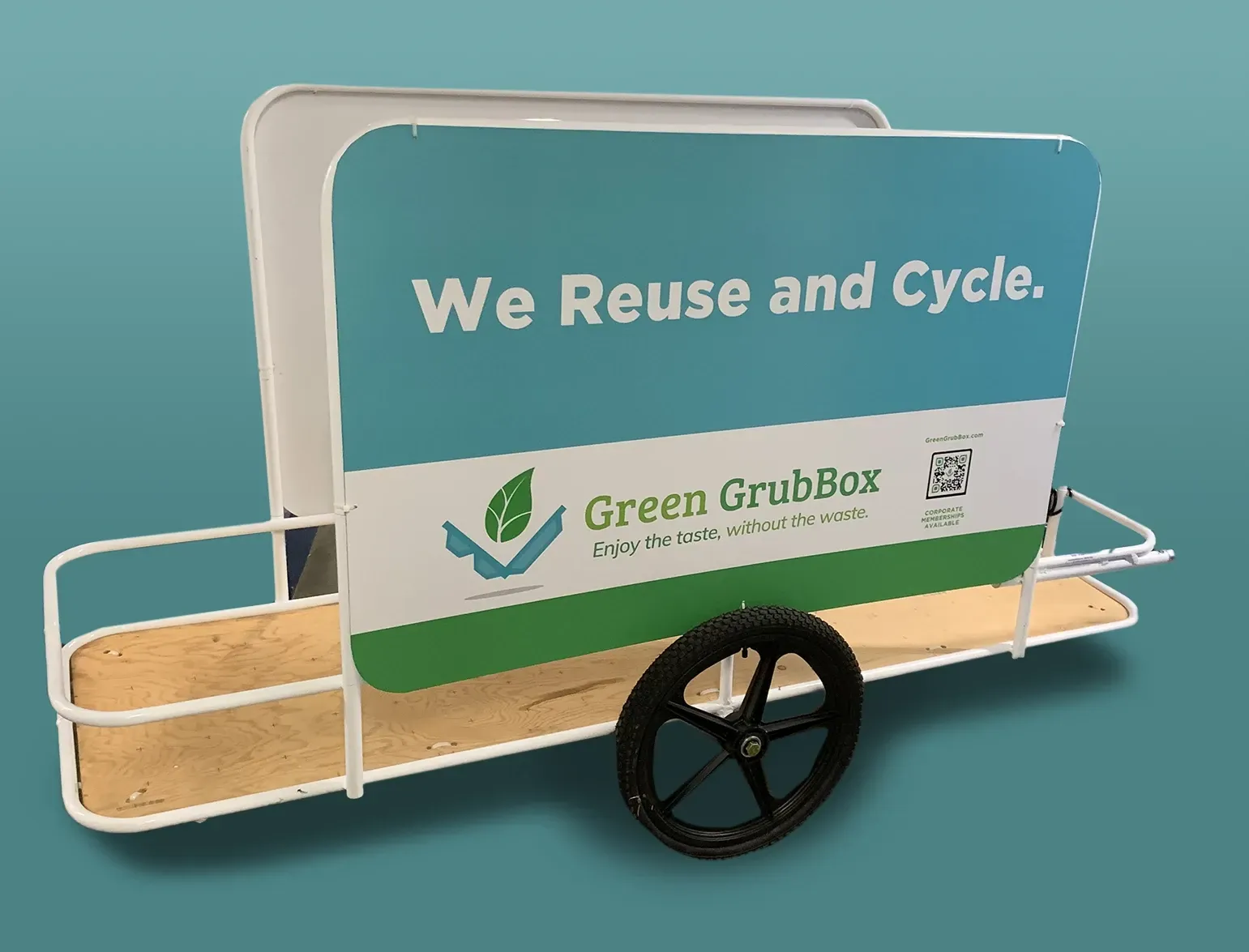 Green EcoBug cart with “We Reuse and Cycle” sign and a large black wheel on a teal background