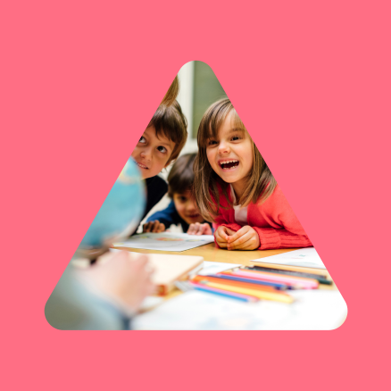 A group of children are sitting at a table with pencils.