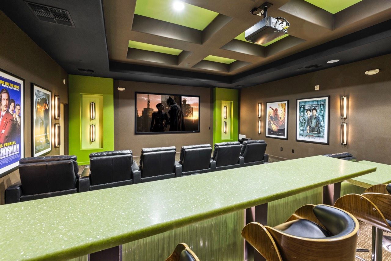 Indoor resident movie theater with projector, screen, and lime-green accents.