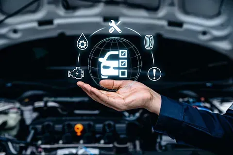 Mechanic presenting glowing car diagnostics icons in front of an open engine bay