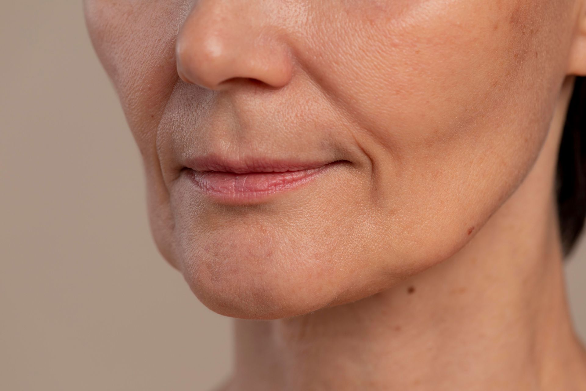 A close up of a woman 's face with wrinkles and a smile.
