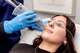 A woman is getting a laser treatment on her face.