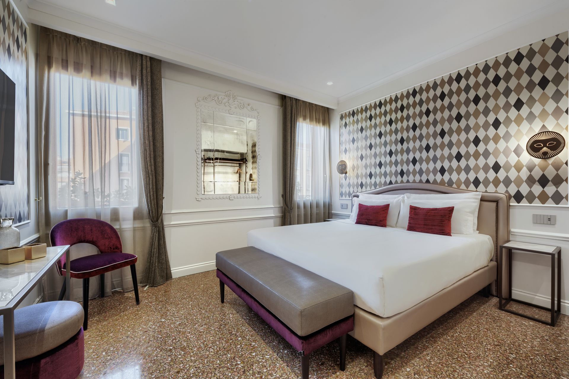 Modern hotel room with large bed, patterned accent wall, window seating, and neutral decor
